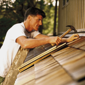 A man using a hammer to fix the roof